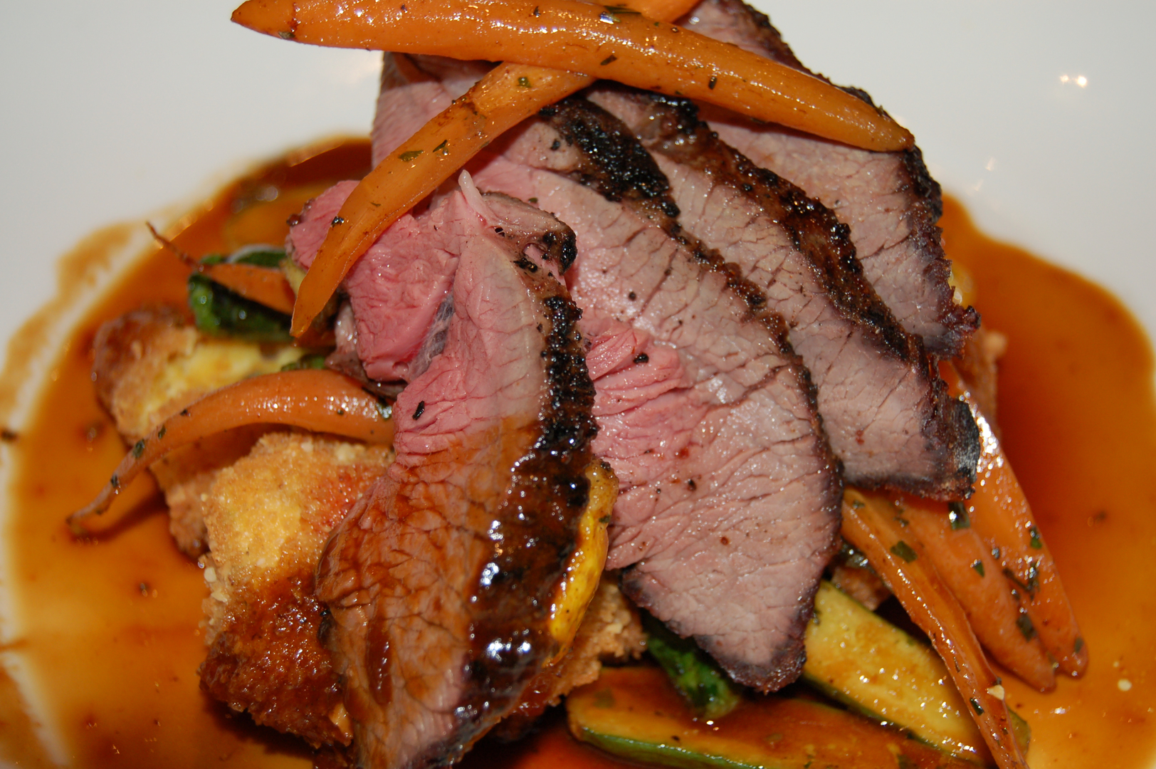 Sliced duck breast with glazed carrots and amber sauce